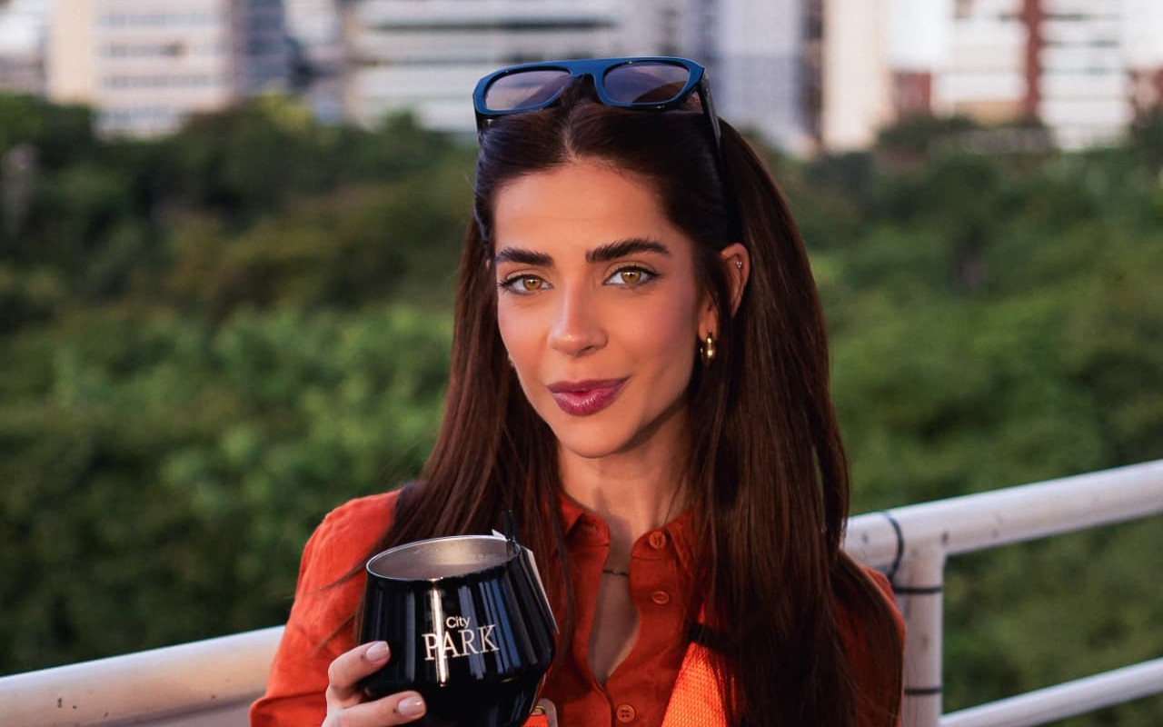 Retrato fotográfico de convidada em experiência elevada com taça City Park